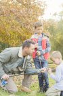Padre insegnare figli a preparare canne da pesca — Foto stock