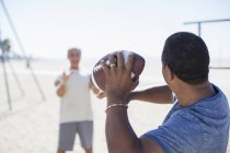 Hommes seniors jouant au football sur la plage — Photo de stock