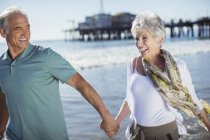 Begeistertes Senioren-Paar läuft am Strand — Stockfoto