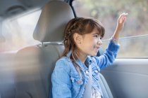 Menina feliz furando mão para fora janela do carro — Fotografia de Stock