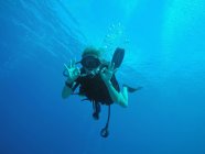 Retrato de mergulhador confiante gesticulando bem debaixo d 'água — Fotografia de Stock