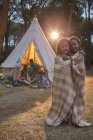 Children wrapped in blanket at campsite — Stock Photo