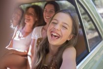Vier Frauen spielen auf dem Rücksitz des Autos — Stockfoto