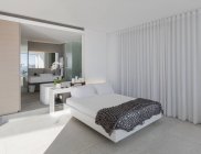 Cama em moderno, casa de luxo vitrine interior quarto com casa de banho privativa — Fotografia de Stock