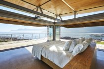 Современная кровать класса люкс с видом на солнечный океан — стоковое фото