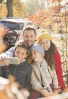 Familia tomando selfie entre las hojas de otoño - foto de stock