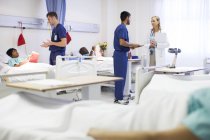 Arzt, Krankenschwestern und Patienten im Krankenhauszimmer — Stockfoto