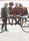 Amigos sonriendo juntos en el estante urbano de bicicletas - foto de stock