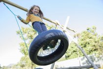 Ragazza che gioca su pneumatico swing — Foto stock