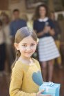 Jovem menina feliz segurando presente — Fotografia de Stock