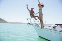 Casal saltando do barco juntos — Fotografia de Stock