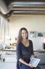 Портрет усміхненої бізнес-леді з цифровим планшетом в офісі — стокове фото