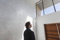 Nachdenklicher Geschäftsmann blickt zum Fenster hoch — Stockfoto