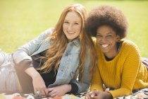 Jeunes femmes heureuses se relaxant ensemble dans le parc — Photo de stock
