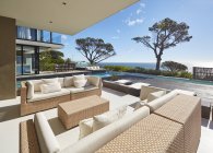 Maison de luxe moderne vitrine patio avec vue sur l'océan ensoleillé — Photo de stock