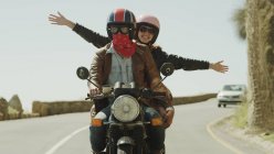 Esuberante giovane donna in moto su strada soleggiata — Foto stock
