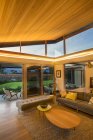 Illuminated wood ceiling over luxury living room open to patio — Stock Photo