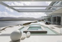 Sunny, tranquil modern luxury home showcase exterior with swimming pool and ocean view — Stock Photo