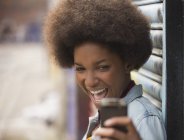 Женщина делает автопортрет с мобильным телефоном на улице — стоковое фото