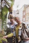 Жіночий флорист допомагає жінці купувати горщики для рослин на вітрині магазину — стокове фото