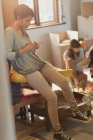 Молодая женщина переписывается с мобильником в новой квартире — стоковое фото