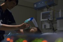 Arzt hält Sauerstoffmaske über dem Gesicht des Patienten auf Intensivstation — Stockfoto