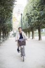 Businessman riding bicycle in park, Paris, France — Stock Photo