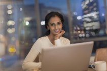 Empresária trabalhando até tarde no laptop no escritório à noite — Fotografia de Stock