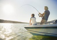 Отец и сын рыбачат на лодке — стоковое фото