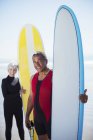 Porträt eines älteren multiethnischen Paares mit Surfbrettern — Stockfoto