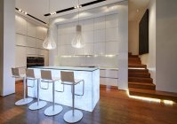 Iluminada moderna cozinha de luxo e escadaria — Fotografia de Stock