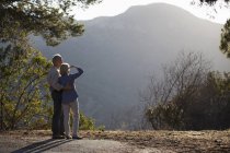 Couple aîné regardant la vue sur la montagne — Photo de stock