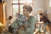 Portrait smiling young woman holding stuffed elephant — Stock Photo