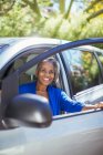 Portrait of confident senior woman getting out of car — Stock Photo