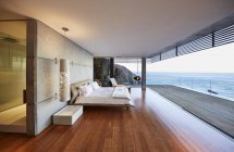 Роскошный современный дом с террасой против морской воды — стоковое фото