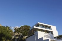 Moderna casa di lusso bianco vetrina esterna sotto il cielo blu — Foto stock