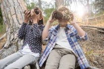 Kinder spielen mit Tannenzapfen im Wald — Stockfoto