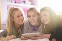 Портрет улыбающихся девочек-подростков с помощью цифрового планшета — стоковое фото