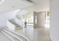Vestíbulo blanco y escalera de caracol en el interior moderno escaparate de casa de lujo - foto de stock