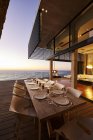 Розкішний сучасний обідній стіл з видом на океан заходу сонця — стокове фото