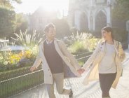 Пара тримається за руки і бігає в міському парку — стокове фото