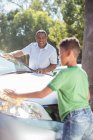 Grandfather and grandson washing car — Stock Photo
