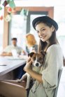 People holding dog at conference table in office — Stock Photo