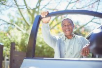 Retrato de homem idoso feliz apoiando-se na porta do carro — Fotografia de Stock