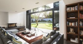 Sunny casa vitrine interior sala de estar aberta para quintal ensolarado — Fotografia de Stock