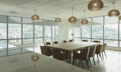 Tavolo conferenze e lampade a sospensione nella moderna sala conferenze dell'ufficio — Foto stock