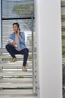 Donna d'affari con scartoffie che parla al cellulare nelle scale moderne — Foto stock