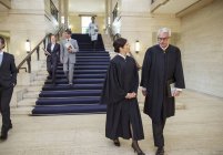 Judges and lawyers walking through courthouse — Stock Photo