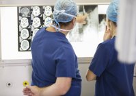 Два лікарі обговорюють рентгенівські та МРТ-сканування пацієнта — стокове фото