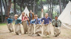 Enfants ayant une course en sac au camping — Photo de stock